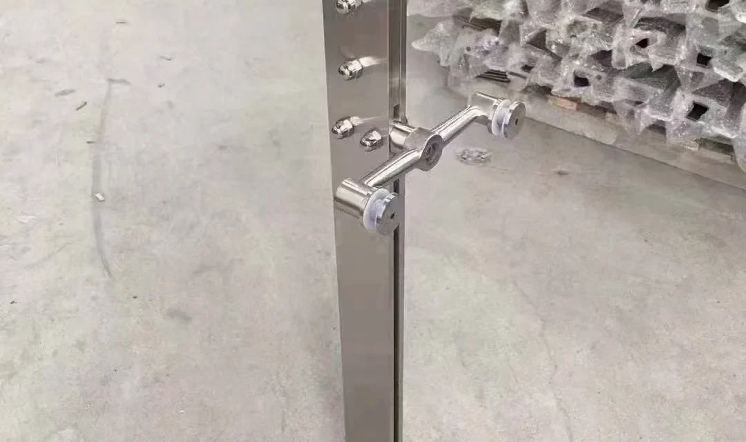 Curved-blade stainless steel glass railing post showing directional profile and project-specific fittings