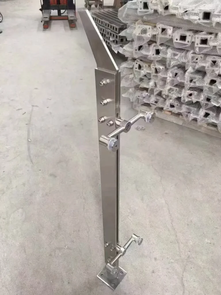 Curved-blade stainless steel glass railing post showing directional profile and project-specific fittings