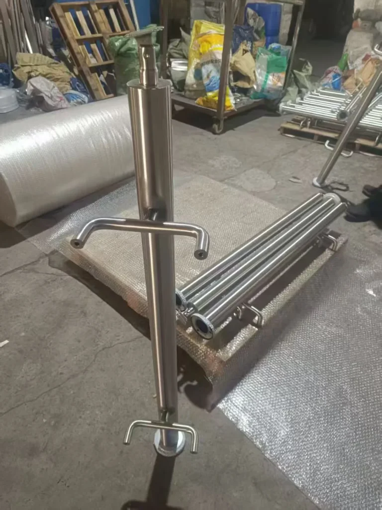 Brushed round stainless steel railing post showing longitudinal grain and fabricated fittings