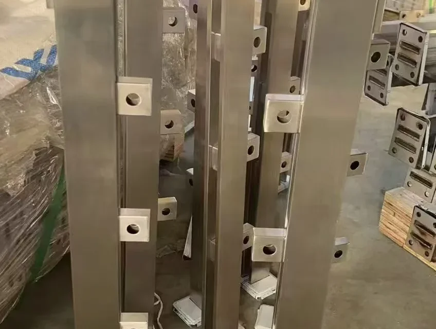 Batch of square stainless steel railing posts with welded glass adapters awaiting quality inspection