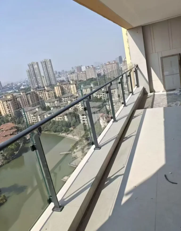 Installed stainless steel glass railing posts on a completed balcony project